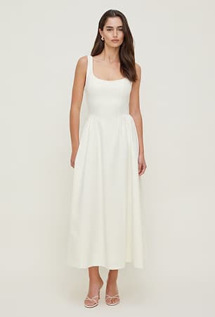 Model is wearing a white scoop neck maxi dress.